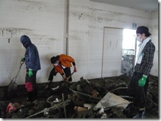 避難所となっている葬祭会館での泥かきボランティア