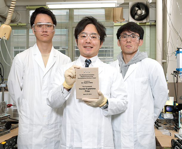 2018年開催の電気化学会第85回大会において受賞した「第14回 Honda-Fujishima Prize」の表彰盾を手にする福助教