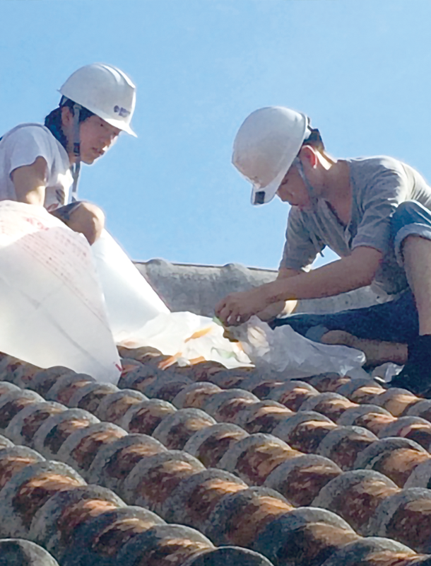 屋根瓦の調査を行う研究室の学生